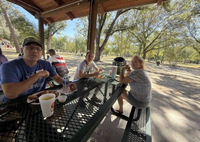 Cycling In Houston - NWCC Recent Activities Gallery 155 Relaxed group enjoying a picnic at a shaded park with trees, ideal for Northwest Cycling Club outdoor activities.