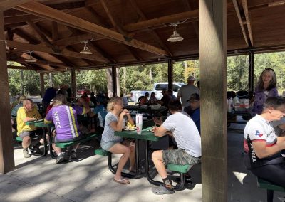 Cycling In Houston - NWCC Recent Activities Gallery 143 Outdoor group cycling event at Northwest Cycling Club picnic pavilion, riders enjoy food break after ride.