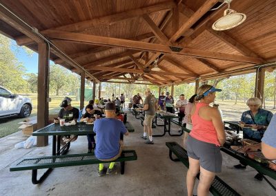 Cycling In Houston - NWCC Recent Activities Gallery 167 People enjoying a picnic at Northwest Cycling Club outdoor pavilion on a sunny day.