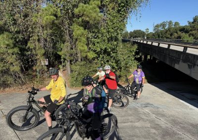 Cycling In Houston - NWCC Recent Activities Gallery 176 Bike riders from Northwest Cycling Club taking a break on a scenic trail under a bridge.