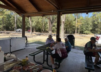 Cycling In Houston - NWCC Recent Activities Gallery 159 Outdoor cycling club members enjoying a meal at a scenic park pavilion after a ride.