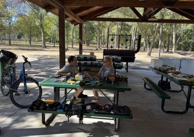 Cycling In Houston - NWCC Recent Activities Gallery 171 Bicycle and bike gear for Northwest Cycling Club at outdoor picnic shelter with trees in background.