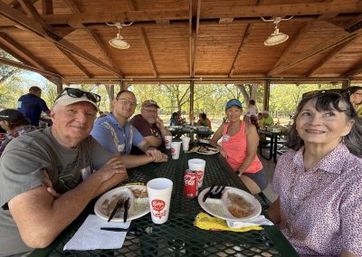 Cycling In Houston - NWCC Recent Activities Gallery 151 Group of cyclists enjoying a meal at Northwest Cycling Club picnic in a park.