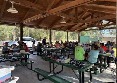 Cycling In Houston - NWCC Recent Activities Gallery 162 Outdoor community cycling event under a wooden pavilion with participants and cycling gear.