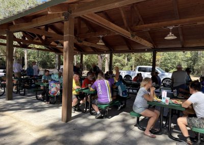 Cycling In Houston - NWCC Recent Activities Gallery 145 Outdoor picnic at Northwest Cycling Club event, cyclists enjoying community and food after ride.