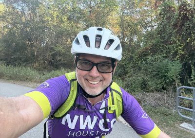 Cycling In Houston - NWCC Recent Activities Gallery 129 Smiling cyclist wearing NWCC Houston jersey and helmet on scenic outdoor ride for Northwest Cycling Club.