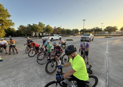 Cycling In Houston - NWCC Recent Activities Gallery 134 Outdoor group cycling event at Northwest Cycling Club in a parking lot at sunset, showcasing community bike rides.