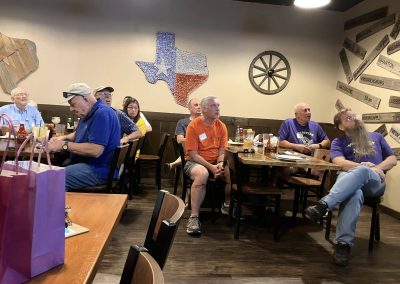 Cycling In Houston - NWCC Recent Activities Gallery 121 Group of cyclists gathered at a Northwest Cycling Club event, enjoying a meal together indoors.