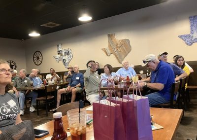 Cycling In Houston - NWCC Recent Activities Gallery 120 Group of cyclists and friends attending a social gathering at a restaurant, celebrating with drinks and conversation.