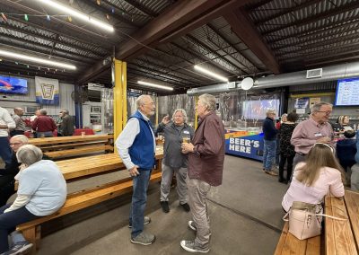 Cycling In Houston - NWCC Recent Activities Gallery 64 People socializing at a Northwest Cycling Club event in an indoor venue, enjoying drinks and conversations.