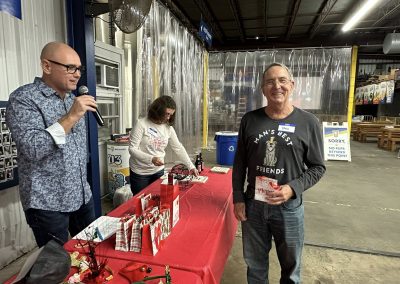 Cycling In Houston - NWCC Recent Activities Gallery 54 Happy man at Northwest Cycling Club holiday event, celebrating with friends and gifts.