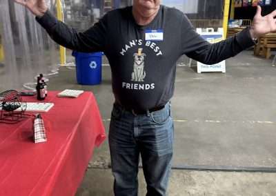 Cycling In Houston - NWCC Recent Activities Gallery 46 1. Happy man with outstretched arms at Northwest Cycling Club event in a warehouse setting.