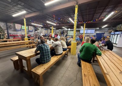 Cycling In Houston - NWCC Recent Activities Gallery 80 Indoor group meeting at Northwest Cycling Club beer hall with wooden benches and holiday decorations.