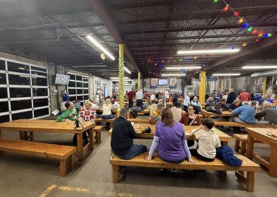 Cycling In Houston - NWCC Recent Activities Gallery 84 Festive indoor gathering at Northwest Cycling Club with holiday decorations and community members enjoying food and conversation.