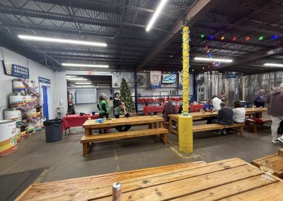 Cycling In Houston - NWCC Recent Activities Gallery 83 Festive indoor gathering with wooden picnic tables, Christmas decor, and socializing, hosted by Northwest Cycling Club.