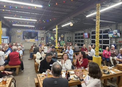 Cycling In Houston - NWCC Recent Activities Gallery 96 A lively indoor gathering at Northwest Cycling Club event with people enjoying food, drinks, and socializing in a decorated space.