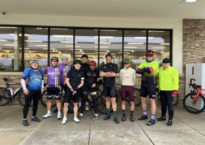 Cycling In Houston - NWCC Recent Activities Gallery 42 Cycling group members outside Northwest Cycling Club stop, ready for a ride, showcasing community and bike attire.