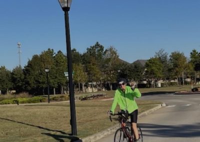 Cycling In Houston - NWCC Recent Activities Gallery 28 Bright cyclist in neon jacket riding on city street during daytime.
